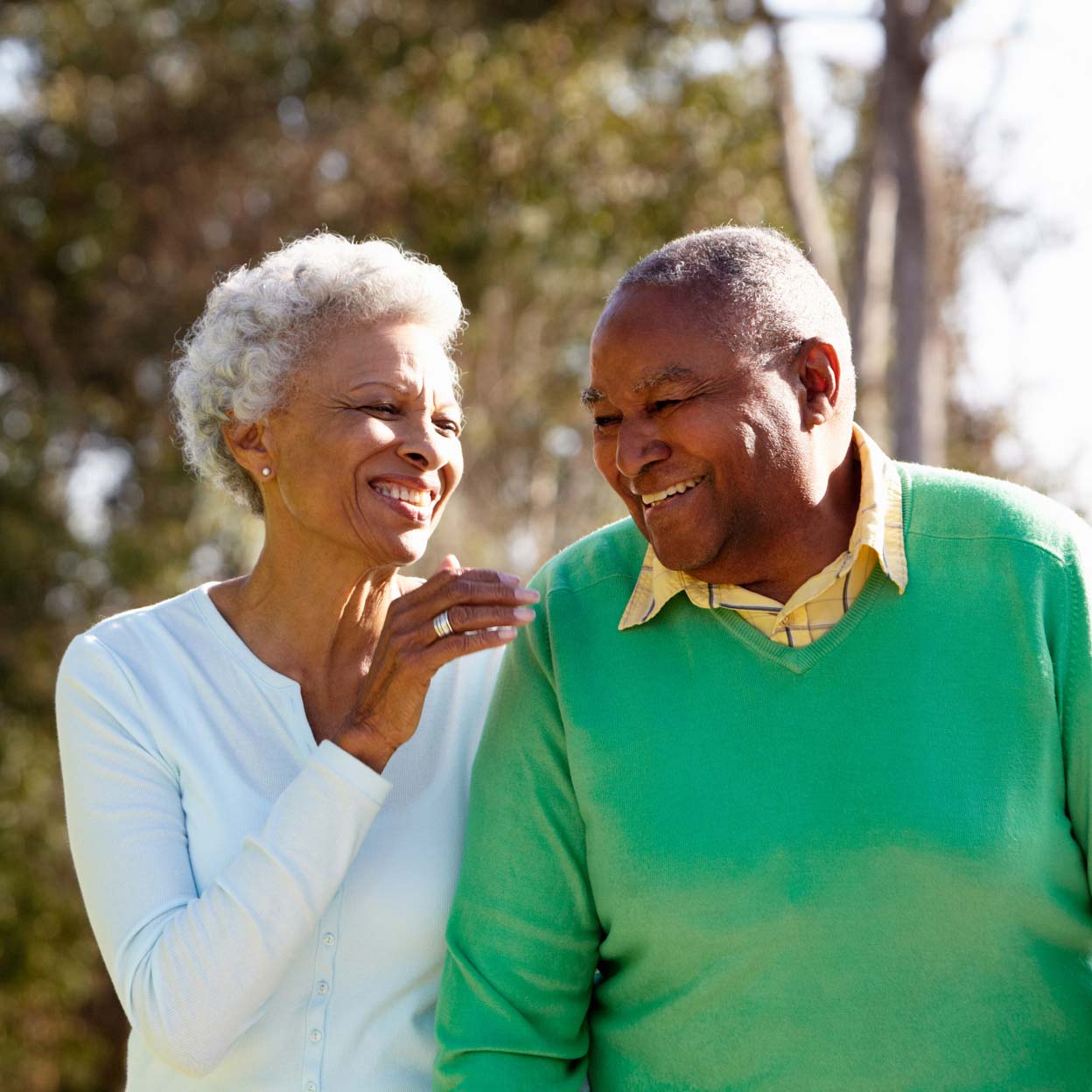 elderly couple smiling and walking